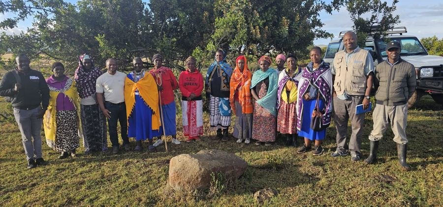 Community consultation with a Maasai community beside two field vehicles, Kenya